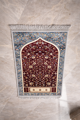 Islamic prayer mat with mihrab arch pattern and detailed floral artwork